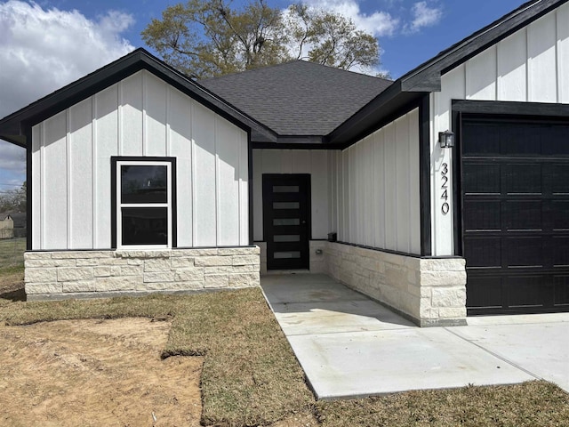 3240 Taft Ave, Groves, TX 77619 - entrance to property featuring stone siding, a shingled roof, board and batten siding, and an attached garage