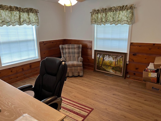 office featuring hardwood / wood-style floors and wooden walls