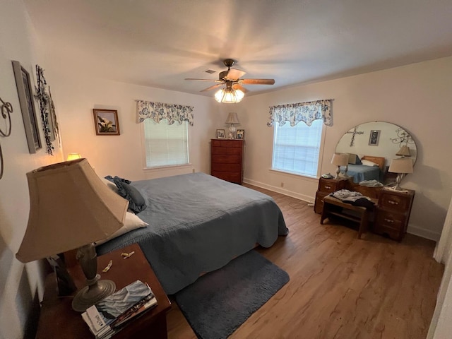 bedroom featuring multiple windows, ceiling fan, and wood-type flooring