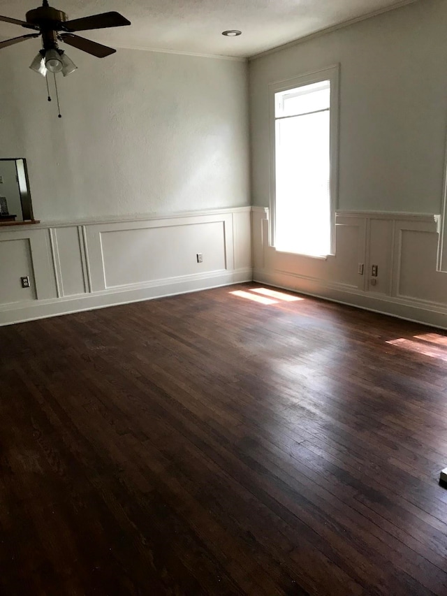 spare room with ceiling fan, dark wood-type flooring, and ornamental molding