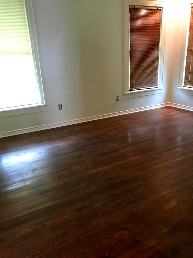 empty room with dark hardwood / wood-style flooring