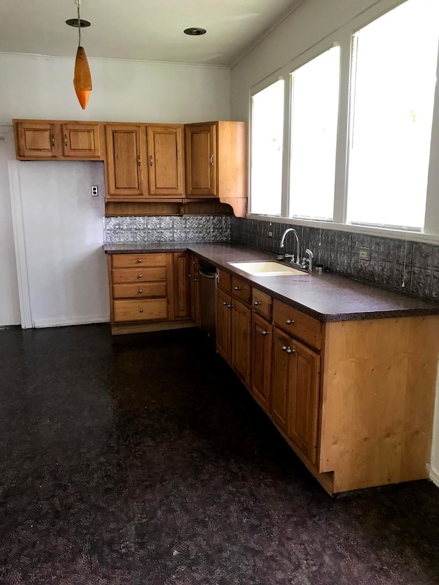 kitchen with backsplash, sink, pendant lighting, and stainless steel dishwasher