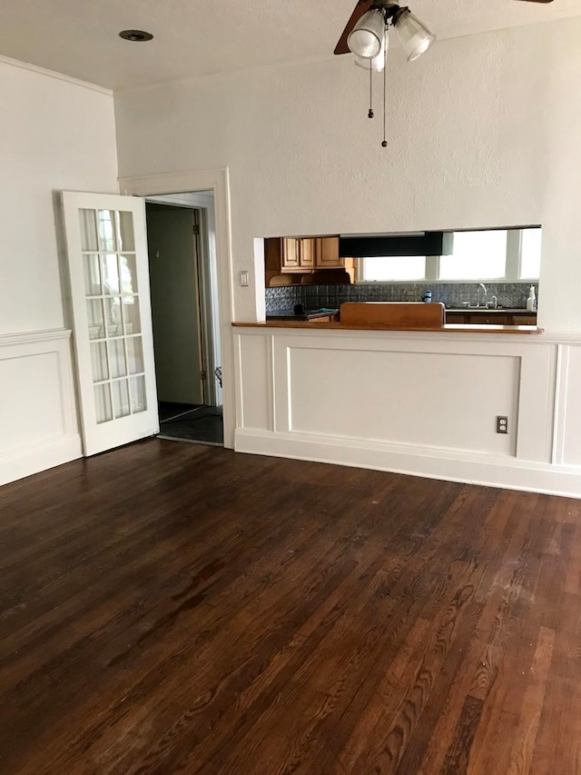 unfurnished living room featuring ceiling fan, sink, and wood-type flooring