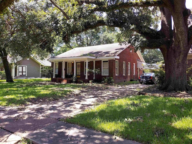 view of front of house featuring covered porch and a front lawn