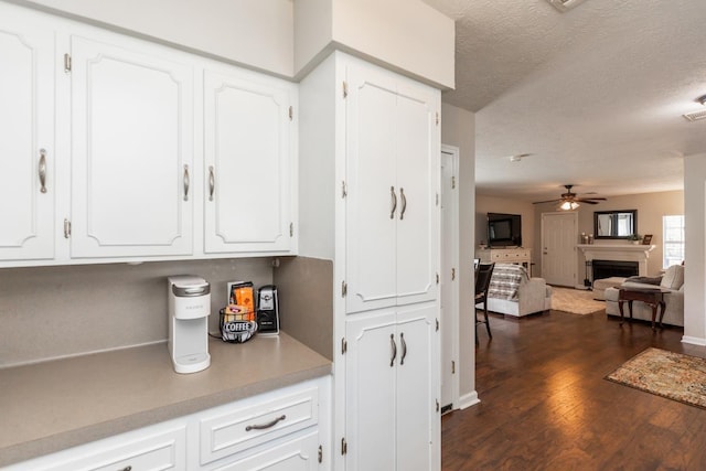 kitchen featuring white cabinetry, ceiling fan, dark wood-type flooring, and a textured ceiling