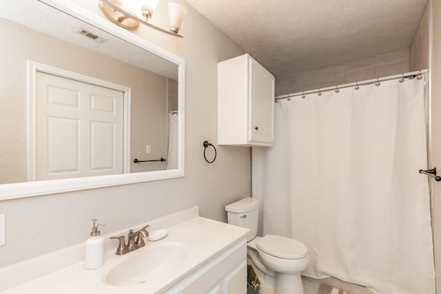 bathroom featuring vanity, toilet, and a textured ceiling