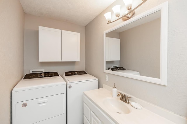 clothes washing area with sink, washer and dryer, and a textured ceiling