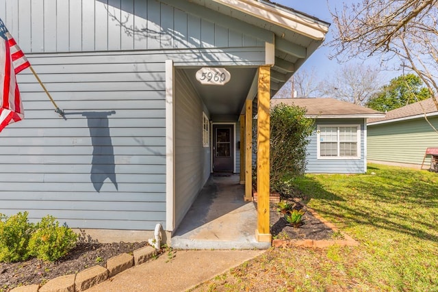 entrance to property with a lawn