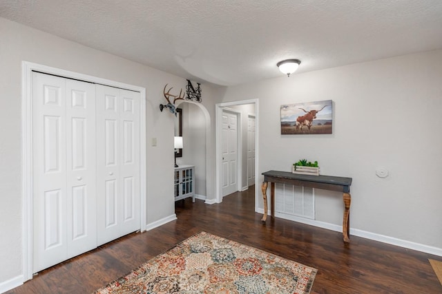 foyer entrance featuring dark hardwood / wood-style floors and a textured ceiling