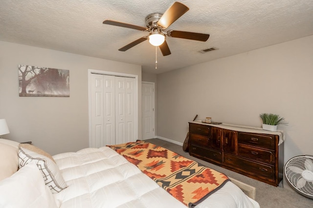 bedroom with ceiling fan, carpet, a textured ceiling, and a closet