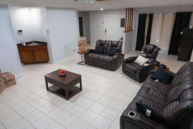 living room featuring visible vents, baseboards, ceiling fan, and light tile patterned flooring