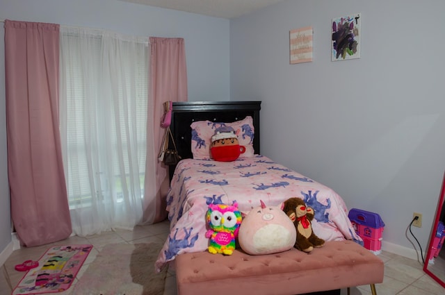 bedroom with baseboards and light tile patterned floors