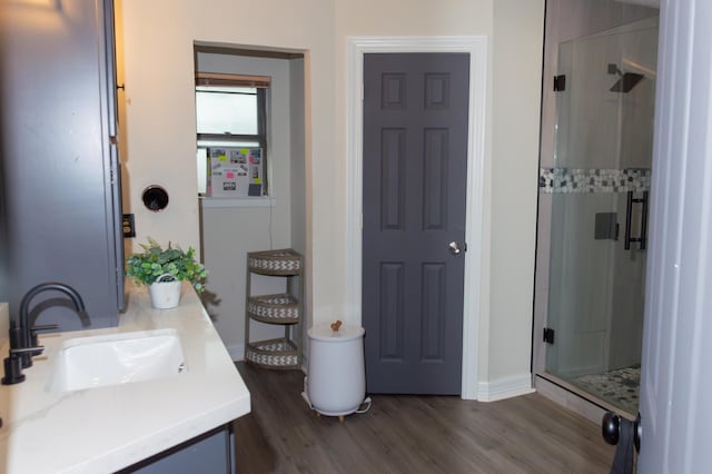 full bathroom featuring vanity, baseboards, a shower stall, and wood finished floors