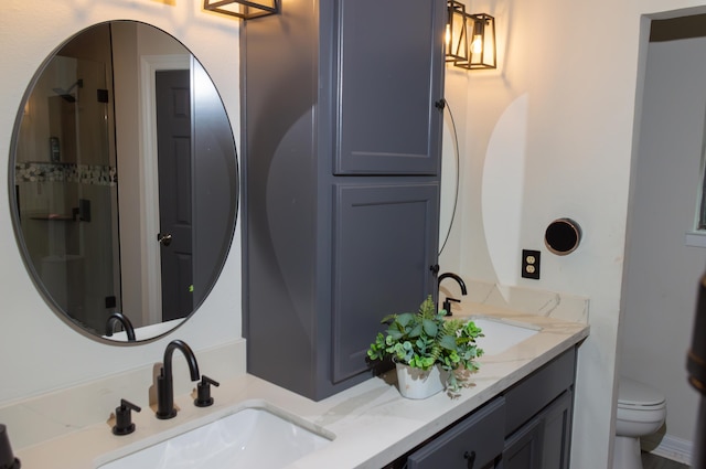 bathroom featuring double vanity, toilet, a shower stall, and a sink