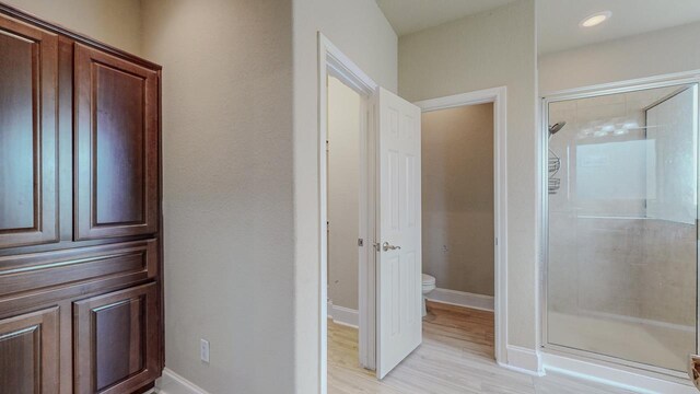 2635 Quiet Corral Ln, Port Arthur, TX 77640 - bathroom with a shower stall, toilet, wood finished floors, and baseboards