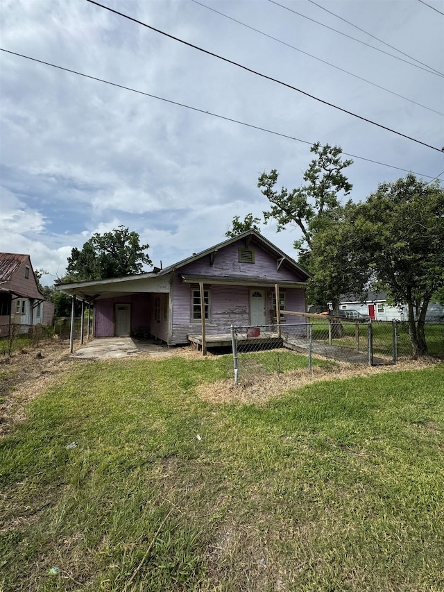 view of front of house with a front lawn and a carport