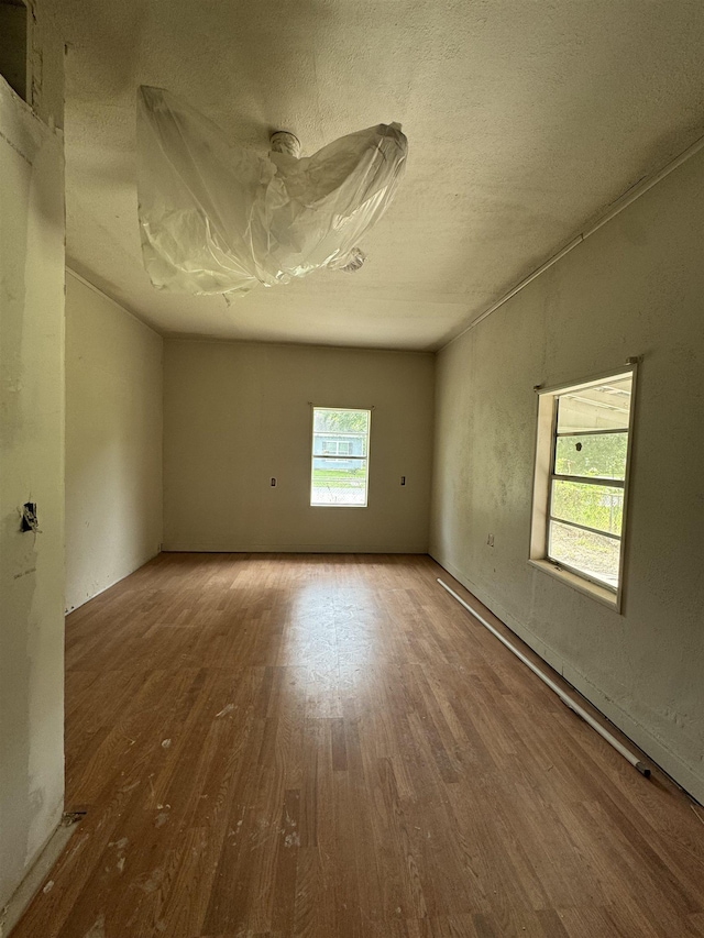 spare room with hardwood / wood-style floors and a textured ceiling