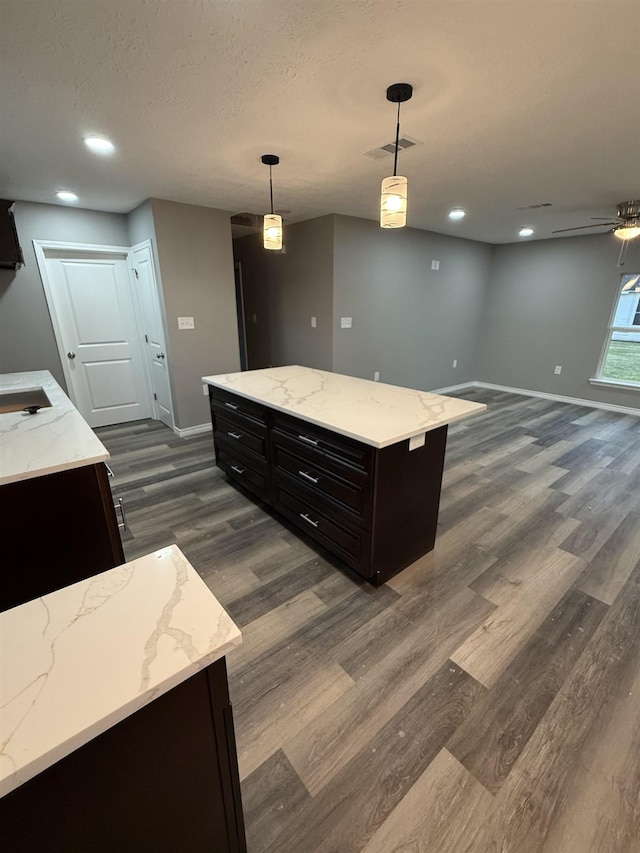 kitchen with baseboards, visible vents, pendant lighting, and dark wood-type flooring