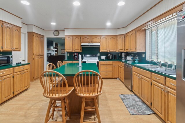 304 Whipoorwill Dr, Silsbee, TX 77656 - kitchen featuring appliances with stainless steel finishes, under cabinet range hood, a center island, light wood-type flooring, and recessed lighting