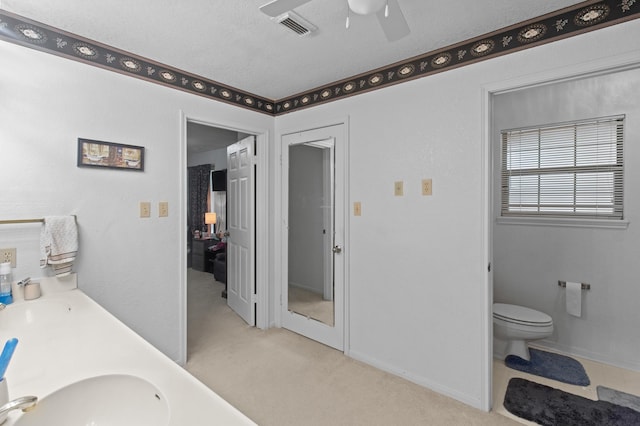 304 Whipoorwill Dr, Silsbee, TX 77656 - bathroom with ceiling fan, toilet, double vanity, a textured ceiling, and baseboards