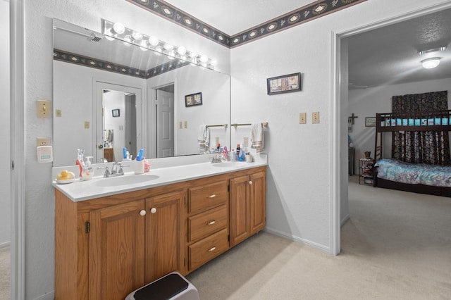 304 Whipoorwill Dr, Silsbee, TX 77656 - ensuite bathroom with double vanity, a textured wall, and baseboards