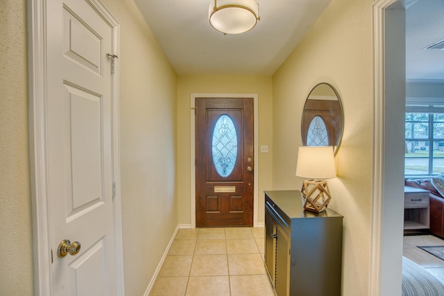 doorway to outside featuring light tile patterned floors and baseboards