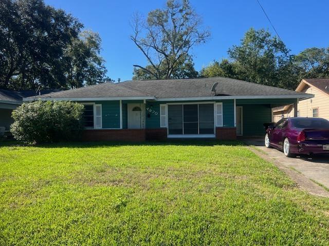 ranch-style home with a front yard and a carport