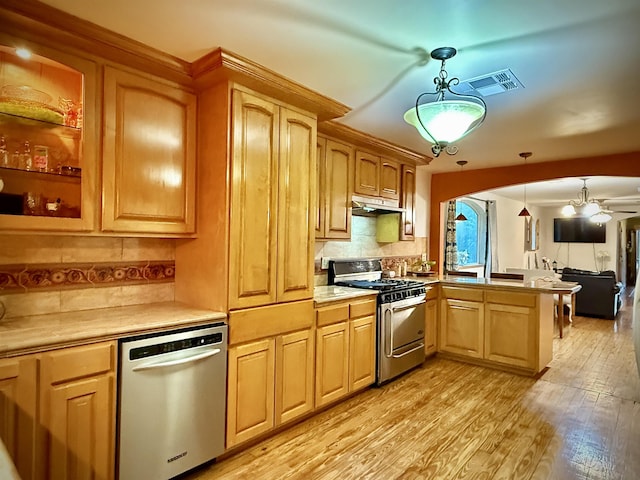 2940 36th St, Port Arthur, TX 77642 - kitchen featuring stainless steel appliances, under cabinet range hood, a peninsula, light countertops, and light wood-type flooring