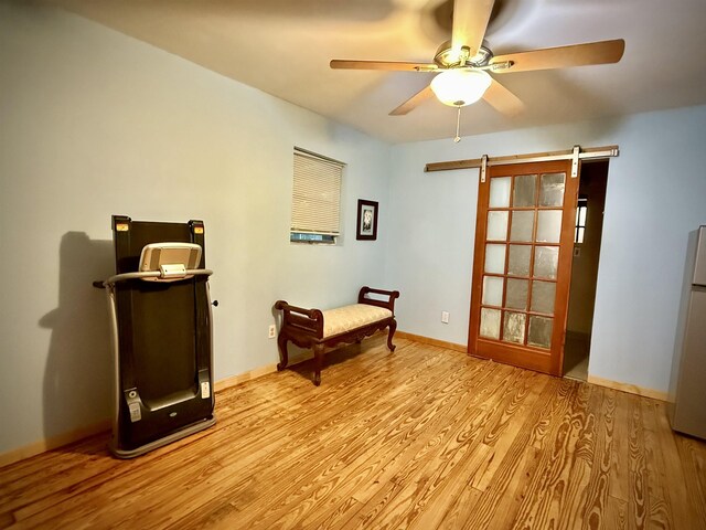 2940 36th St, Port Arthur, TX 77642 - living area with a barn door, light wood-style flooring, and a ceiling fan