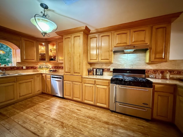2940 36th St, Port Arthur, TX 77642 - kitchen featuring gas range, under cabinet range hood, dishwasher, light wood-style floors, and tasteful backsplash