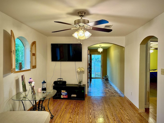 2940 36th St, Port Arthur, TX 77642 - living area with arched walkways, ceiling fan, and wood finished floors