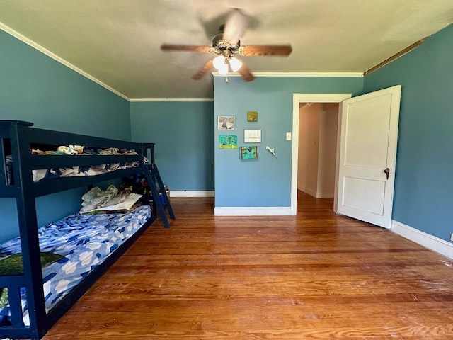 bedroom featuring hardwood / wood-style flooring, ceiling fan, and crown molding