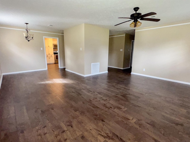 empty room featuring dark hardwood / wood-style flooring, ceiling fan with notable chandelier, and ornamental molding