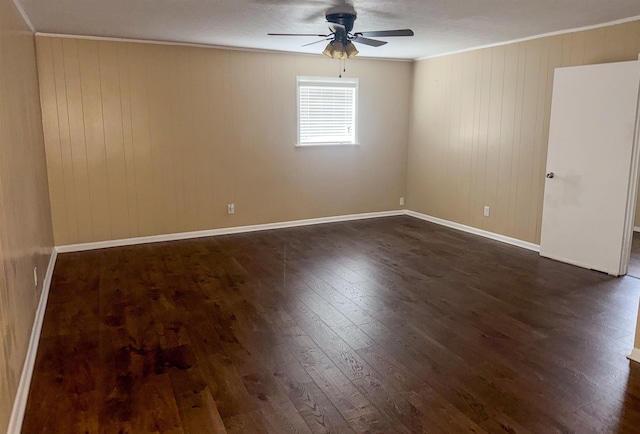 unfurnished room with ornamental molding, ceiling fan, dark wood-type flooring, and wood walls