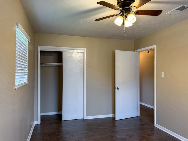 unfurnished bedroom featuring ceiling fan, dark hardwood / wood-style floors, a textured ceiling, and a closet