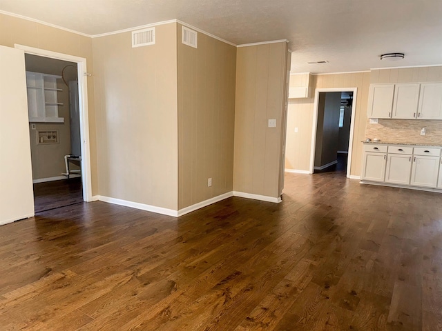 unfurnished living room featuring dark hardwood / wood-style flooring and crown molding