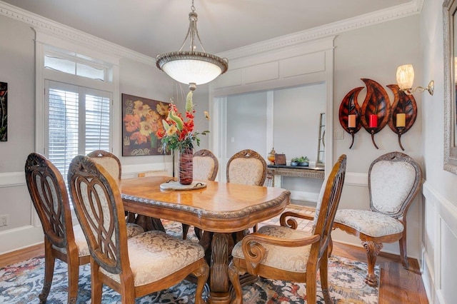 dining space with hardwood / wood-style flooring and ornamental molding