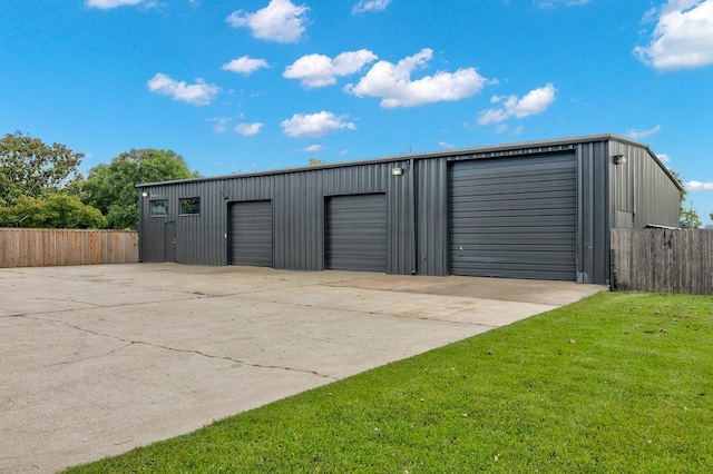 view of outdoor structure with a lawn and a garage