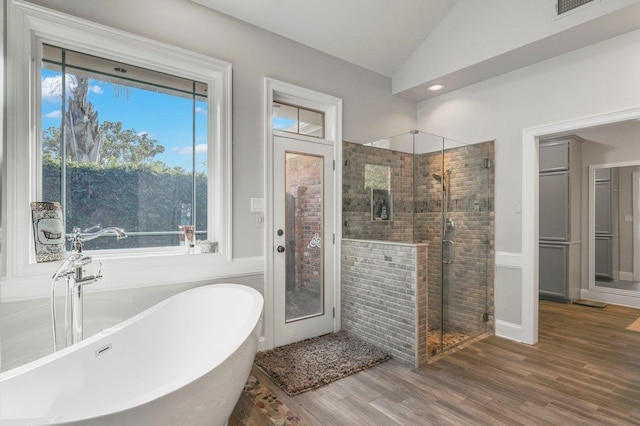 bathroom with shower with separate bathtub, vaulted ceiling, and a healthy amount of sunlight