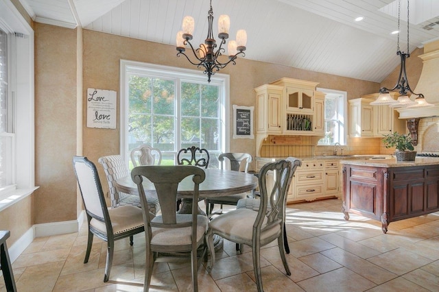 dining area featuring a notable chandelier, lofted ceiling, sink, and light tile patterned floors