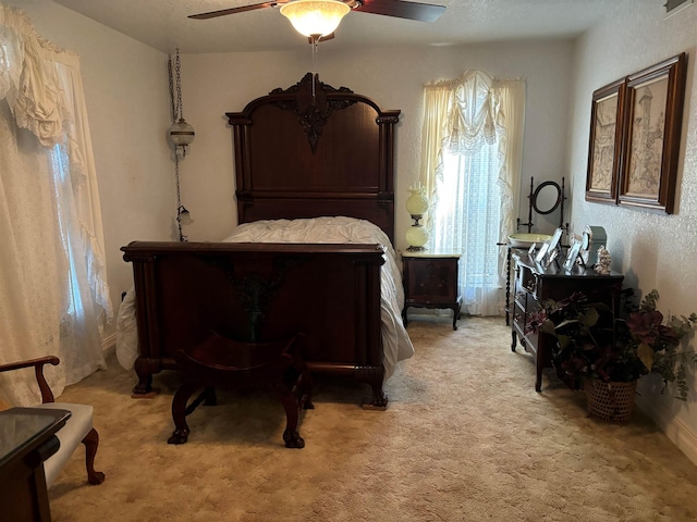 bedroom featuring light colored carpet and ceiling fan