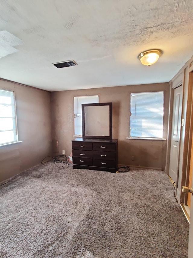 unfurnished bedroom featuring a textured ceiling and carpet floors