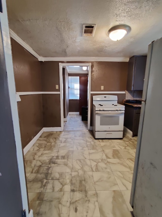 kitchen featuring white appliances, a textured ceiling, and ornamental molding