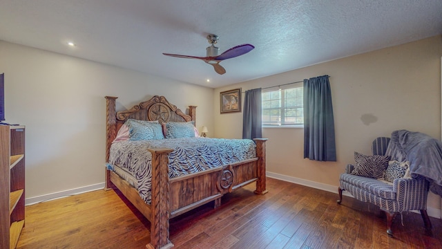 bedroom with ceiling fan, a textured ceiling, and hardwood / wood-style flooring