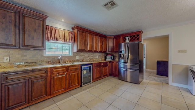 kitchen with a textured ceiling, sink, light tile patterned floors, stainless steel fridge with ice dispenser, and wine cooler