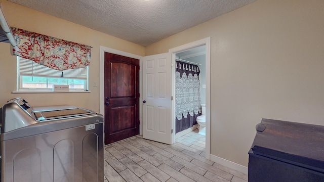 laundry room featuring independent washer and dryer and a textured ceiling