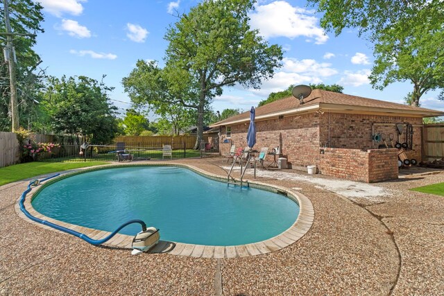 view of swimming pool featuring a fenced backyard, a patio area, and a fenced in pool