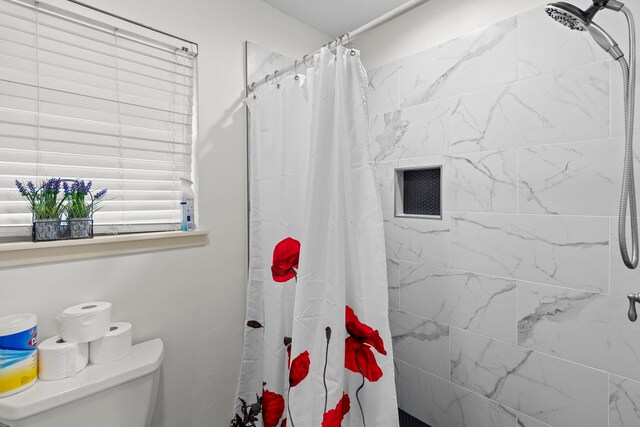 bathroom featuring toilet, visible vents, and tiled shower