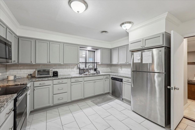 kitchen with visible vents, ornamental molding, gray cabinets, stainless steel appliances, and a sink