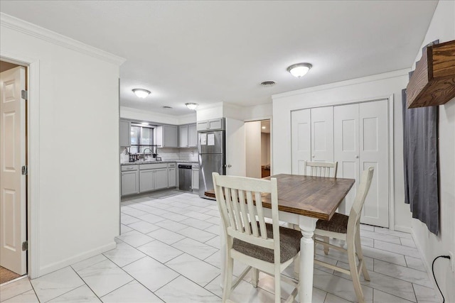 dining room featuring crown molding, baseboards, and visible vents